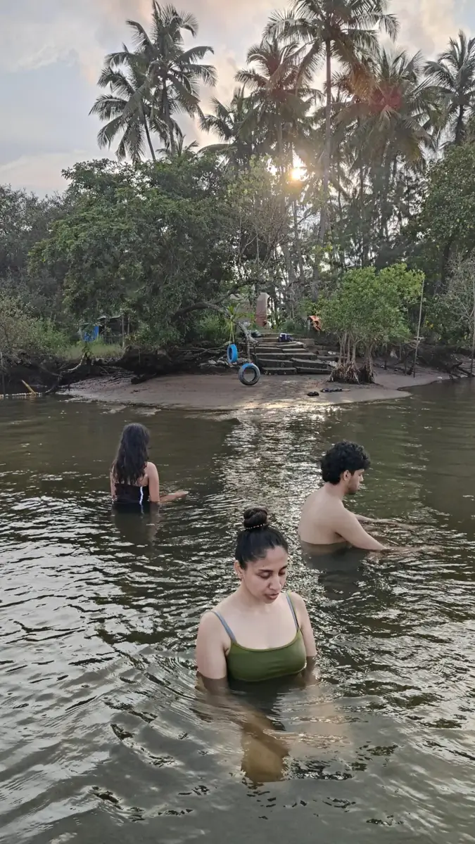 Guests standing in the river at dusk, winding down for the evening