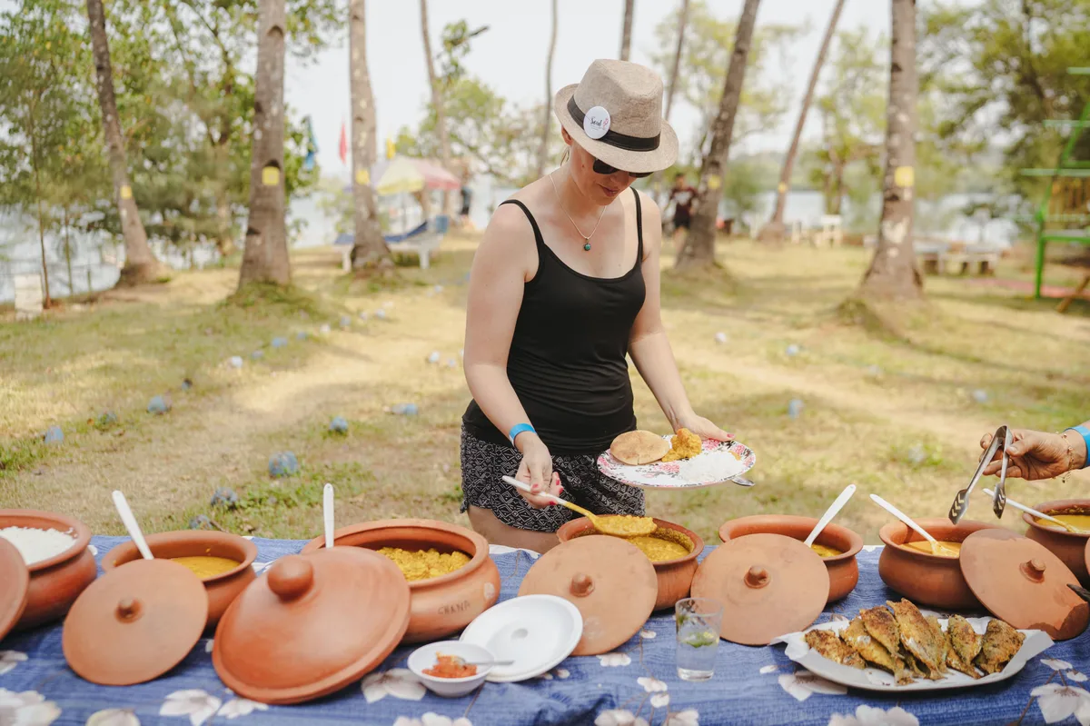 Guest serving herself from a spread of clay-pot dishes
