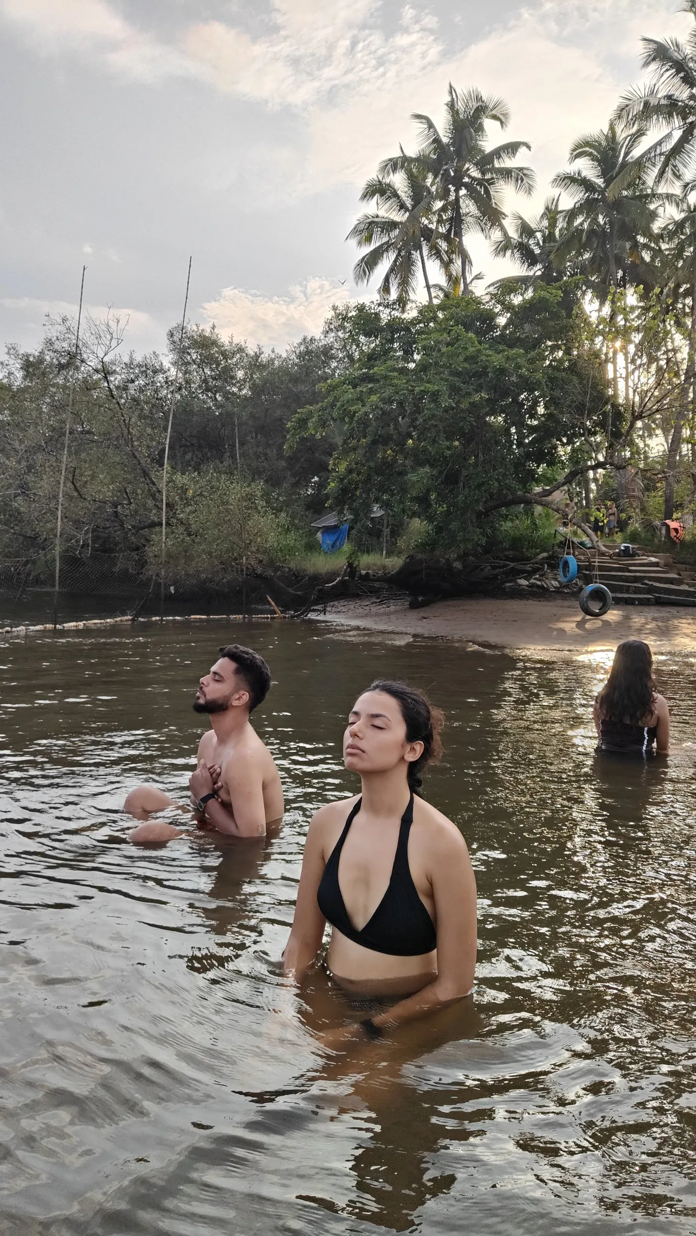 Guests meditating together, waist-deep in the river