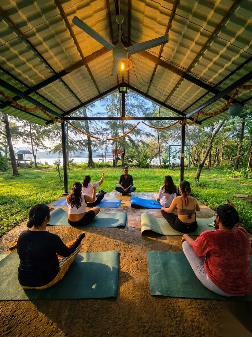 Arnold leading a sunrise session in the open-air shala, overlooking the river